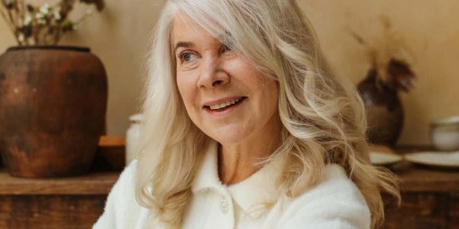 Une femme souriante avec des cheveux blanc longs